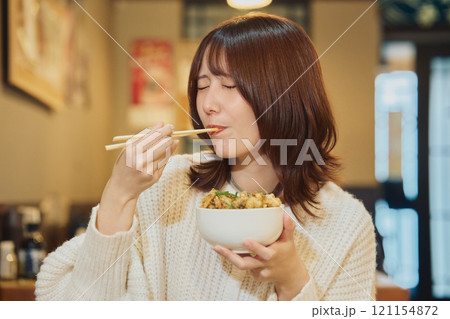 海鮮丼を美味しそうに食べる女性　撮影協力・ピアbandai 121154872