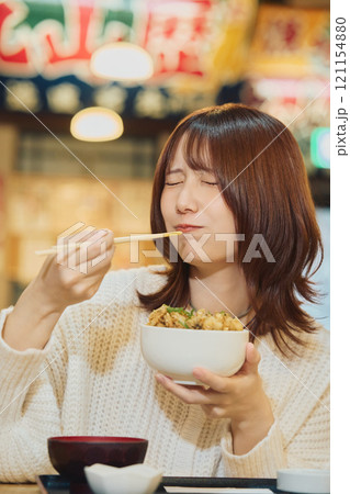 海鮮丼を美味しそうに食べる女性　撮影協力・ピアbandai 121154880