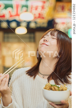 海鮮丼を美味しそうに食べる女性　撮影協力・ピアbandai 121154882