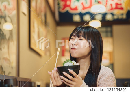 海鮮丼を美味しそうに食べる女性 撮影協力・ピアbandai 海鮮丼を美味しそうに食べる女性 撮影協力・ピアbandai 121154892
