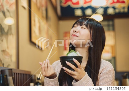 海鮮丼を美味しそうに食べる女性　撮影協力・ピアbandai 121154895