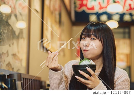 海鮮丼を美味しそうに食べる女性 撮影協力・ピアbandai 海鮮丼を美味しそうに食べる女性 撮影協力・ピアbandai 121154897