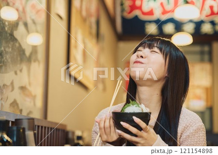 海鮮丼を美味しそうに食べる女性　撮影協力・ピアbandai 121154898