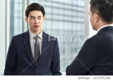 two asian businessmen chatting in office 121155208