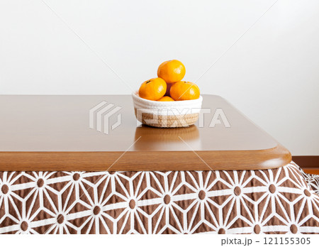 コタツのテーブルに置かれたカゴ盛りミカン 121155305