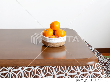 コタツのテーブルに置かれたカゴ盛りミカン コタツのテーブルに置かれたカゴ盛りミカン 121155306