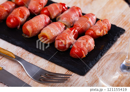 Miniature sausage links wrapped in bacon Miniature sausage links wrapped in bacon 121155419