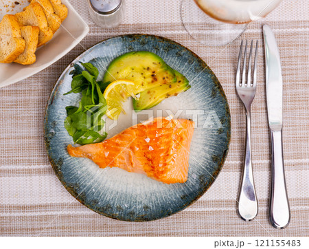 Salmon served with avocado and herbs 121155483