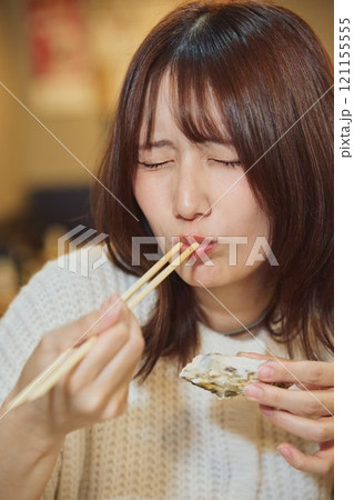 おいしそうに牡蠣を食べる女性　撮影協力・ピアbandai 121155555