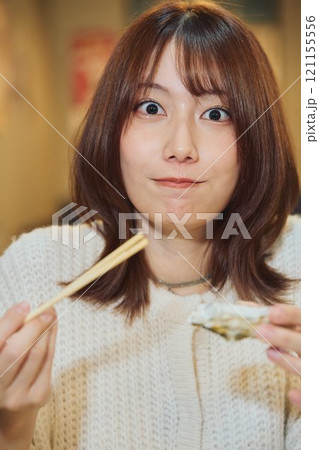 おいしそうに牡蠣を食べる女性　撮影協力・ピアbandai 121155556