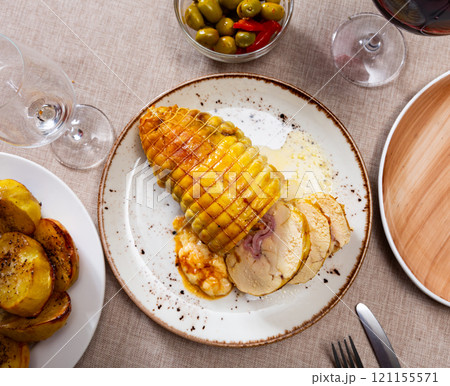 Stuffed chicken served with potatoes on platter 121155571