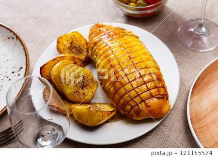 Chicken fillet baked with bacon filling, garnished with fried potato slices. Chicken fillet baked with bacon filling, garnished with fried potato slices. 121155574