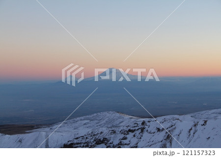 Stunning Snowy Mountain Landscape with Clear Blue Sky and Prominent Peak in the Distance Stunning Snowy Mountain Landscape with Clear Blue Sky and Prominent Peak in the Distance 121157323