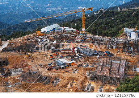 construction site with a crane and an excavator. Development of foundation pit for building under construction 121157766