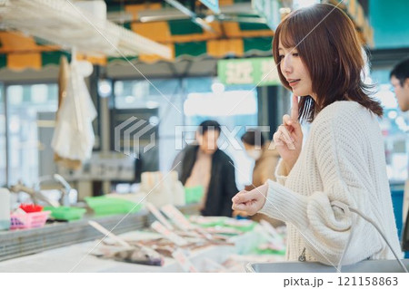 市場で買い物する若い女性 121158863