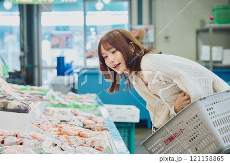市場で買い物する若い女性 市場で買い物する若い女性 121158865