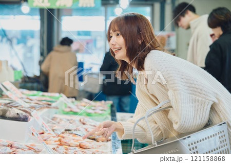 市場で買い物する若い女性 121158868