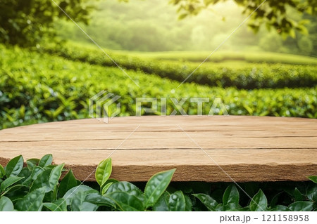 Empty wooden table or wooden desk with tea plantation nature background with green leaves as frame Product display natural background concept Empty wooden table or wooden desk with tea plantation nature background with green leaves as frame Product display natural background concept 121158958