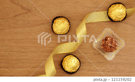 バレンタインやクリスマスの贈り物に喜ばれるチョコレートギフトのゴールドリボンイメージ 121159202