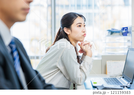 オフィスで同僚と話をするビジネスパーソン 121159383