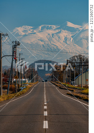 どこまでも続く北海道の一本道と雪化粧の旭岳と紅葉 121160732