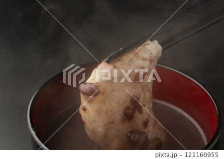 お汁粉の餅を箸で持ち上げる お汁粉の餅を箸で持ち上げる 121160955