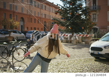 A Joyful Woman Skating Happily in a Festive Square Adorned with a Beautiful Christmas Tree A Joyful Woman Skating Happily in a Festive Square Adorned with a Beautiful Christmas Tree 121164694