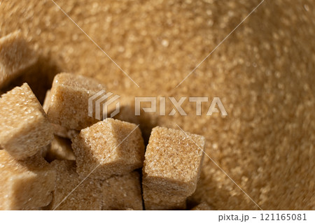 Brown cane unrefined demerara sugar in the form of crystals and cubes 121165081