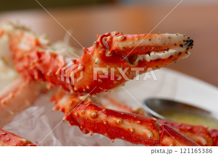 Claws of the crab Paralithodes camtschaticus on a white plate in a restaurant. Contain cholesterol, but low in saturated fat and also have omega-3 fatty acid. 121165386