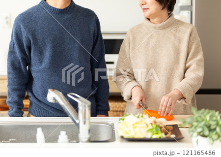 キッチンで鍋料理の準備をするミドル夫婦 121165486