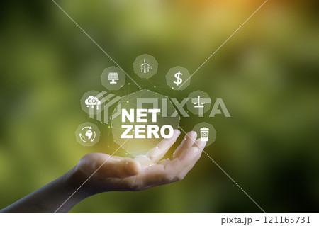 Net zero, Reduce emissions, carbon neutral and ESG concept. net zero greenhouse gas emissions target Climate neutral. Human hand holding eco green energy system icon around on blue background 121165731