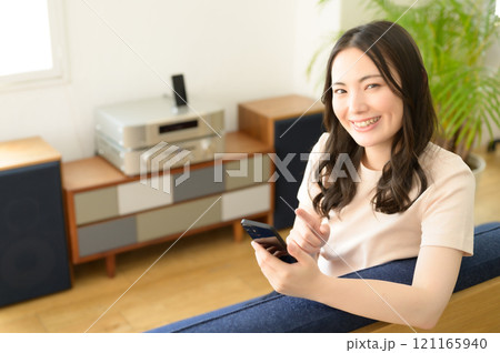 リビングのソファーに座ってスマホを見る女性 リビングのソファーに座ってスマホを見る女性 121165940