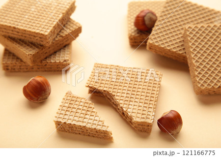 Square chocolate wafer biscuits with hazelnut on beige background. 121166775
