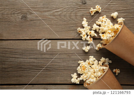 Popcorn in brown cups. Two cups of popcorn on grey wooden background. Sweet popcorn. 121166793