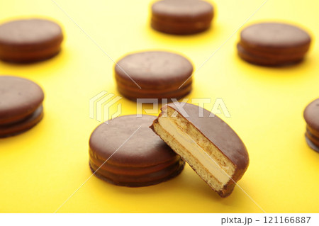 Choco pie chocolate coated snacks on yellow background with copy space. Choco pie chocolate coated snacks on yellow background with copy space. 121166887