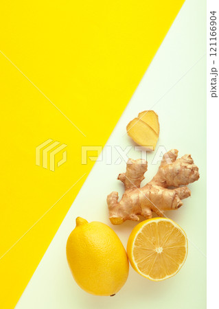 Lemon and ginger on white and yellow background. Vertical photo Lemon and ginger on white and yellow background. Vertical photo 121166904