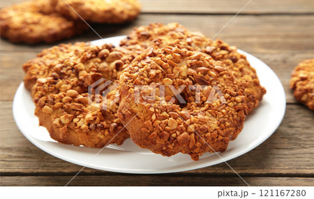 Peanut cookies on white plate on grey wooden background. Bakery products. Peanut cookies on white plate on grey wooden background. Bakery products. 121167280