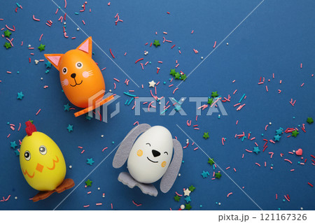 Easter holiday concept with cute handmade eggs, dogs, cat and chicks on blue background. Easter holiday concept with cute handmade eggs, dogs, cat and chicks on blue background. 121167326
