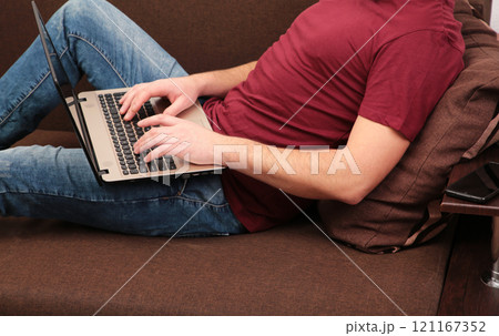Businessman working at home with a laptop on sofa. Businessman working at home with a laptop on sofa. 121167352