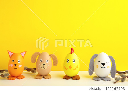 Easter holiday concept with cute handmade eggs, dogs, chicks and cat on yellow background. Easter holiday concept with cute handmade eggs, dogs, chicks and cat on yellow background. 121167408