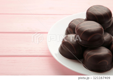 Chocolate sweets on a pink wooden background. Biscuit Chocolate sweets on a pink wooden background. Biscuit 121167409