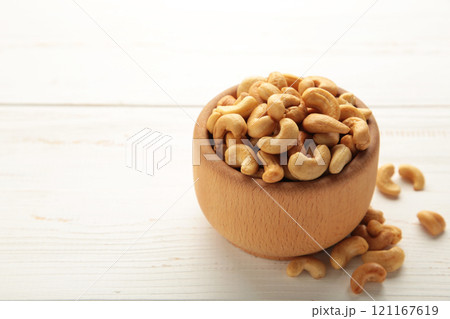 Cashew nuts on wooden bowl on white background. Top view. 121167619