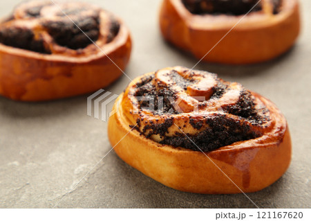 Bun with poppy seeds on grey background. 121167620