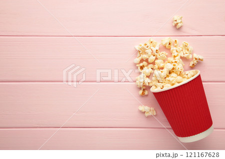 Delicious popcorn on light pink wooden background. Space for text 121167628