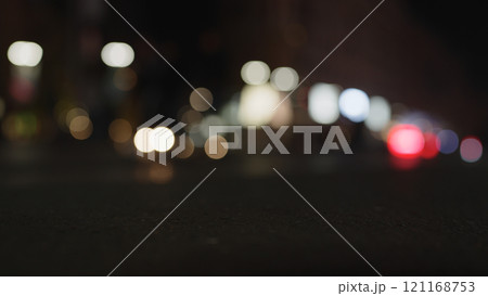Low angle bokeh background of night city with car light passing by 121168753