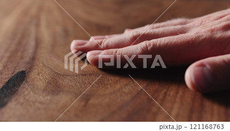 closeup man hand check oiled black walnut surface 121168763
