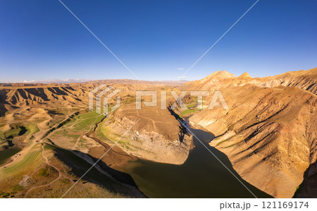 Panoramic aerial view on picturesque Azat reservoir and Eranos mountain at bright sunny evning sunset. Lake with blue water in arid area and Yeranos mountains range. Beautiful landscape. Armenia. Panoramic aerial view on picturesque Azat reservoir and Eranos mountain at bright sunny evning sunset. Lake with blue water in arid area and Yeranos mountains range. Beautiful landscape. Armenia. 121169174