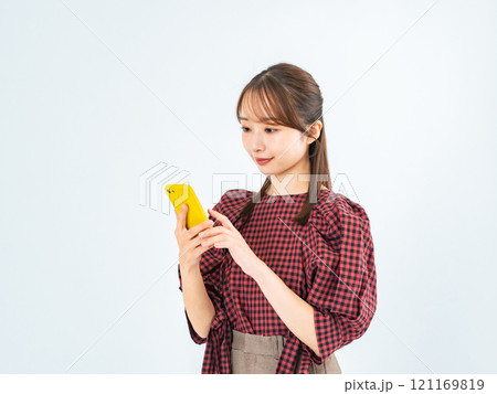 スマホを見るカジュアルウェアの女性 スマホを見るカジュアルウェアの女性 121169819