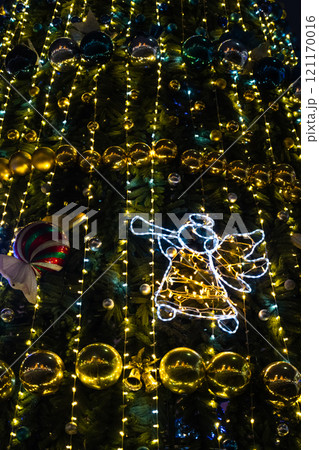 Christmas decorations on the Christmas tree. An angel singing on a trumpet 121170016