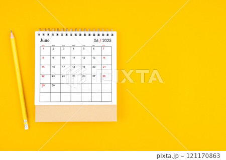 June 2025 desk calendar and wooden pencil on yellow color background. 121170863